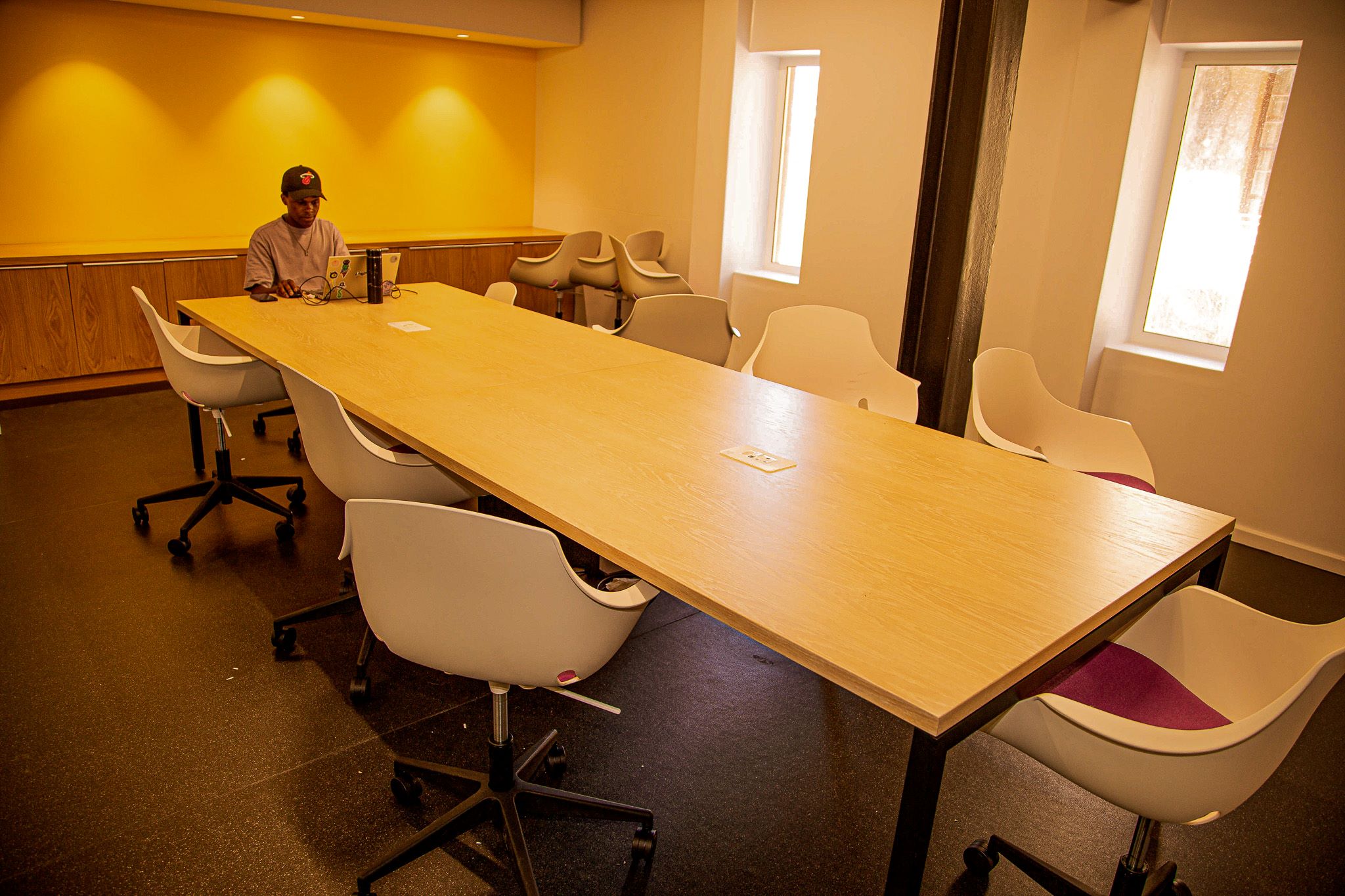 Student on laptop seated front of the long table in the training room, LLL @ Chris Hani