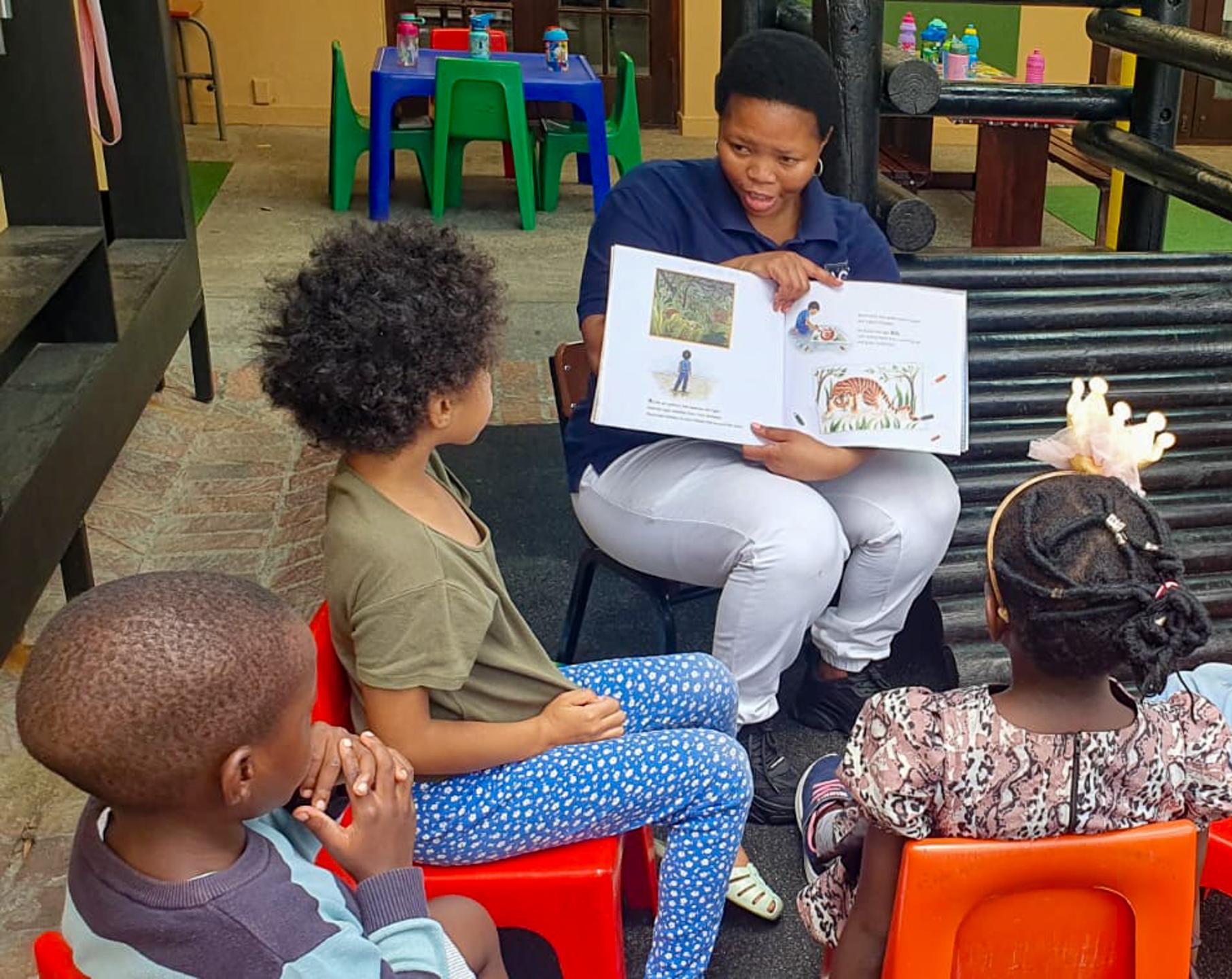 Librarian reads to seated children