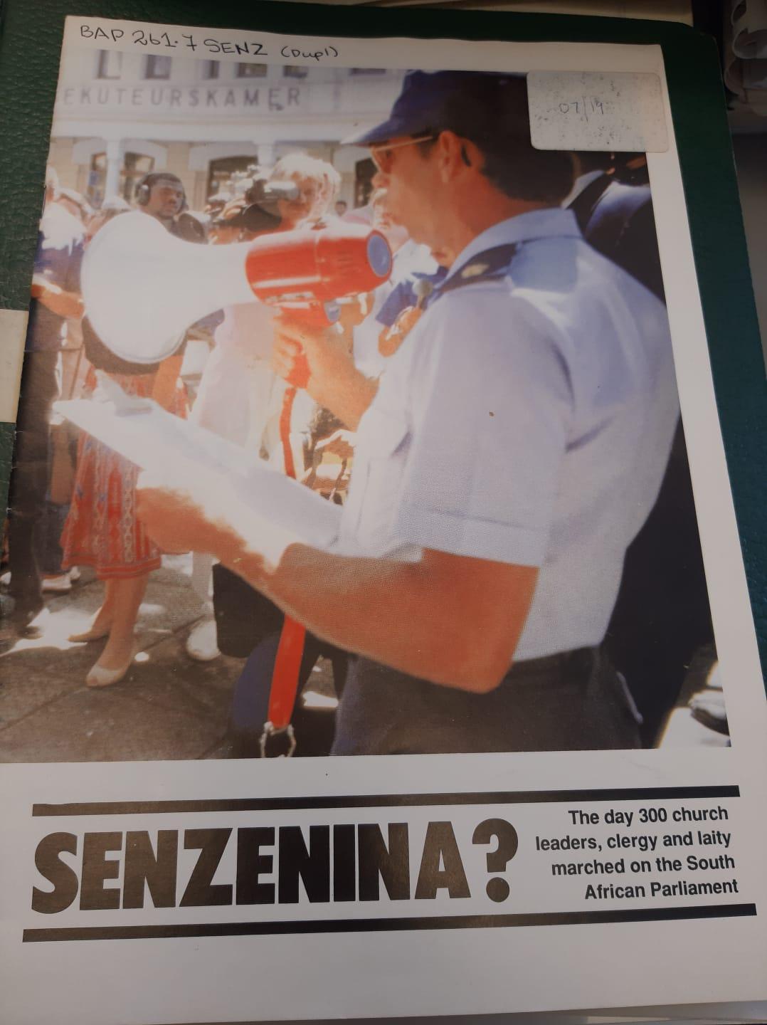 Politcal poster with policeman holds paper and loudspeaker infront of gathered crowd