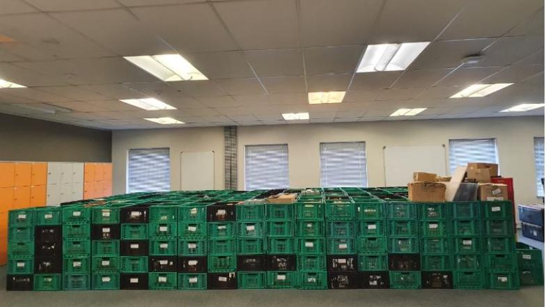Stacked crates on floor: African Studies collections material awaiting processing