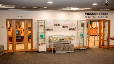 View of outside of Knowledge Commons. Display cabinets between the entrance and exit doors