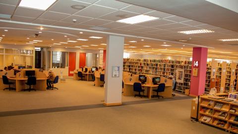 View of student extention 4. Open plan floor area with clusters of study seats with PCs. Rows of bookstacks on the right side.