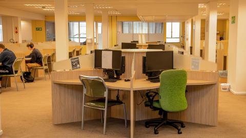 Clusters of computer workstations and students seated at study desks