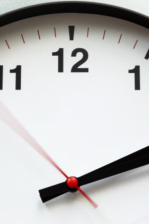 Round white clock with hands shown on green background