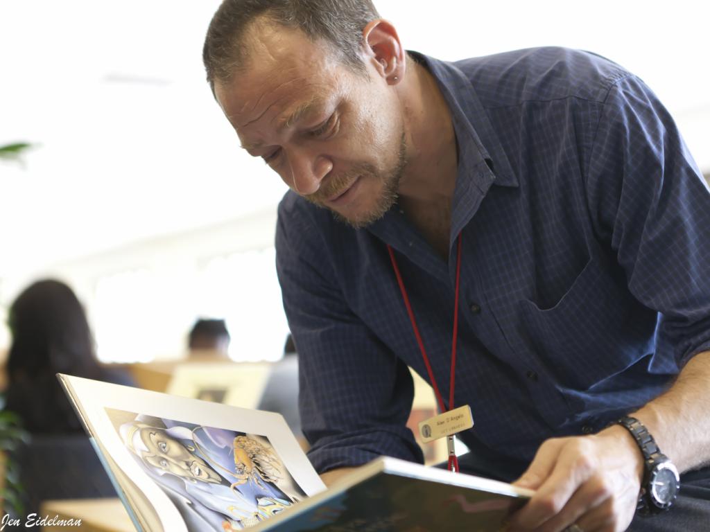 Alex D'Angelo leaned over as he examines a book in the libraries