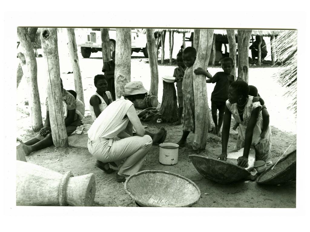 Pamela Reynolds speaks to children and mother in a village